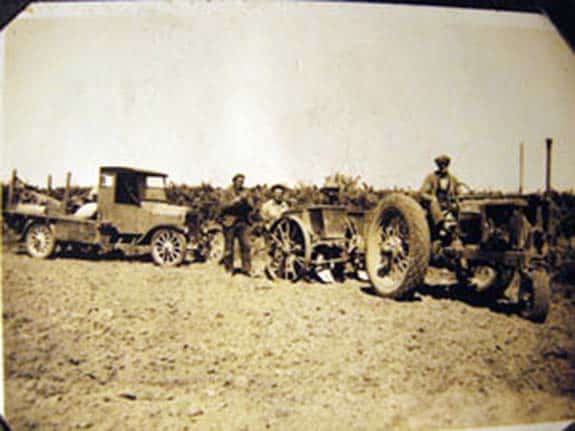 Walter Mark Oakley driving tractor with employees, using a pre 1924 truck and planting potatoes, 1935.